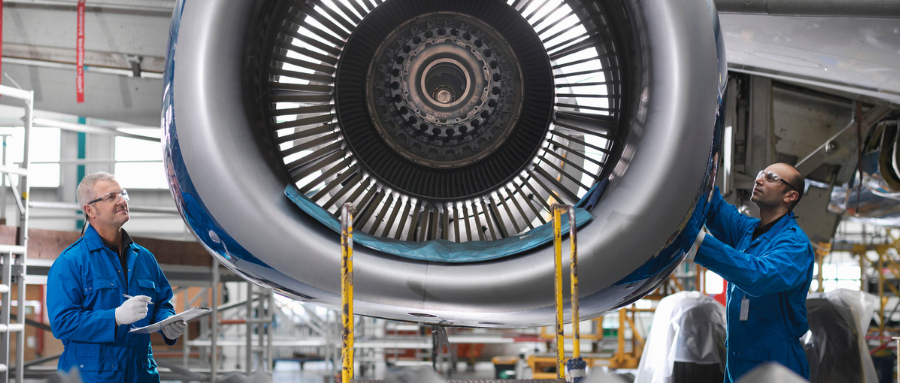 Two men maintain and ensure the proper functioning of a jet engine